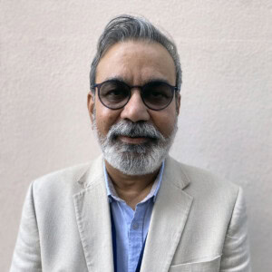 Ramesh Singh, profile photo of South Asian man in a tan suit